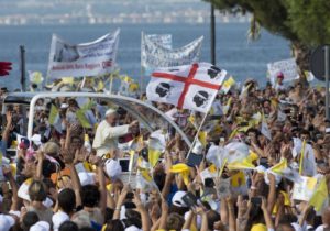 Pope Francis waves to the crowd from his pope-mobile as he arrives at the Sanctuary of the Madonna of Bonaria, to celebrate a mass on the occasion of his one day visit to the island of Sardinia, in Cagliari, Italy, Sunday, Sept. 22, 2013.  Francis denounced what he called big business's idolatry of money over man as he traveled Sunday to one of Italy's poorest regions to offer hope to the unemployed and entrepreneurs struggling to hang on. Sardinia, known for its pristine beaches and swank vacation homes, has been particularly hard-hit by Italy's economic crisis, with factories closing and more and more of the island's families forced to seek charity. (AP Photo/Alessandra Tarantino)