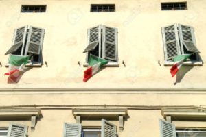 State flags of Italy on the windows of facade of house in city Reggio Emilia